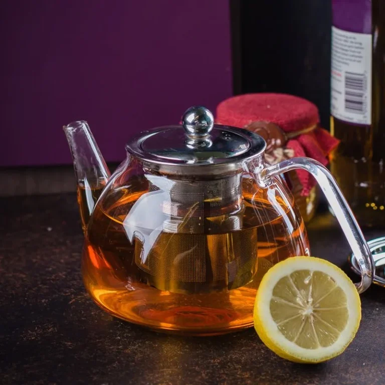 Dzbanek z herbatą i cytryną na ciemnym tle stołu