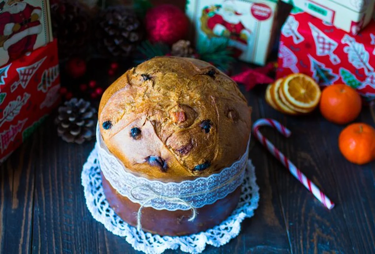 Panettone z dekoracją owocową i Bożonarodzeniową na drewnianym tle
