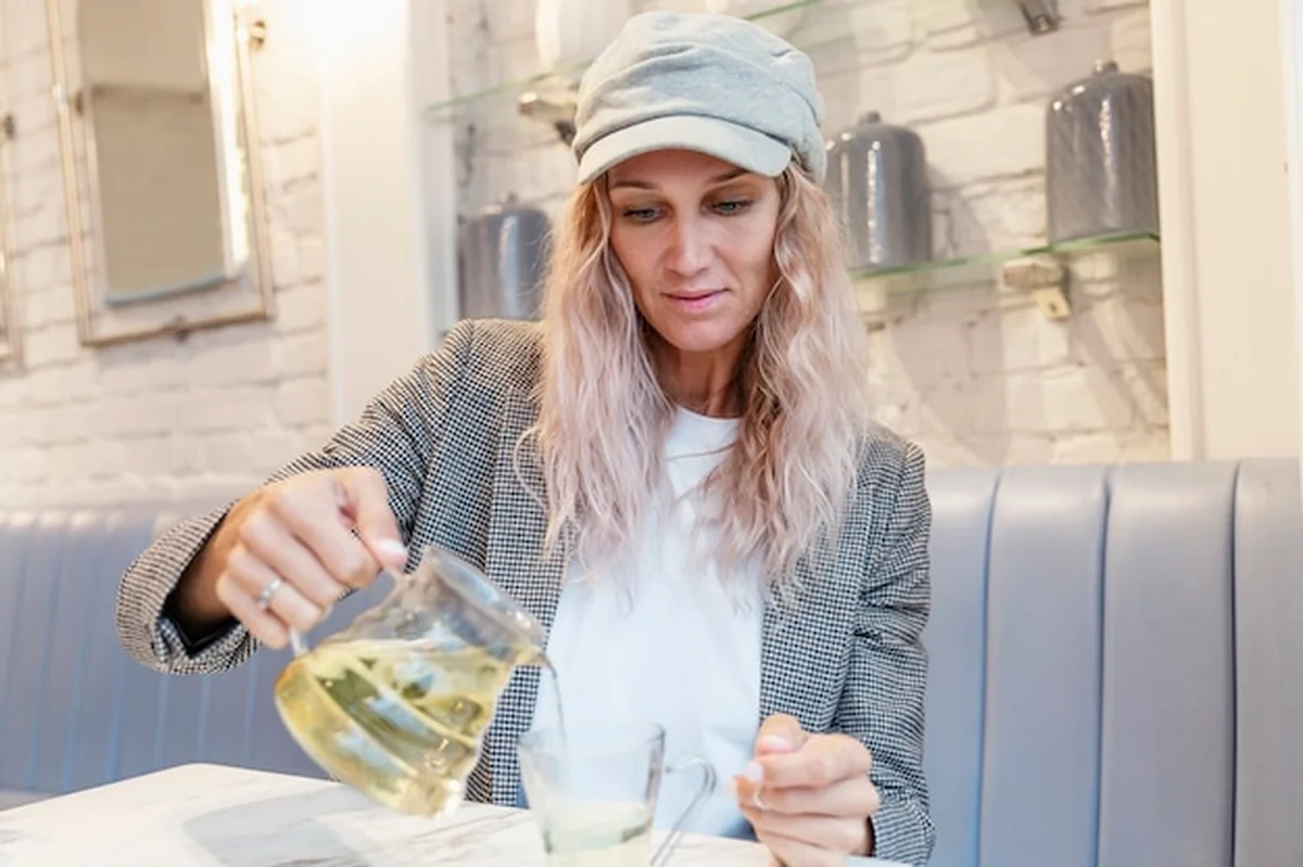 Młoda kobieta pije herbatę w kawiarni