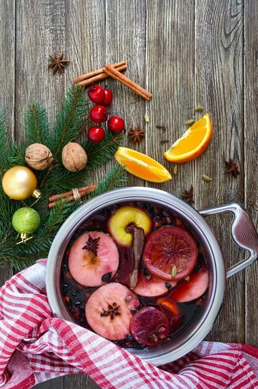 Gorące grzane wino na drewnianym stole z przyprawami i owocami