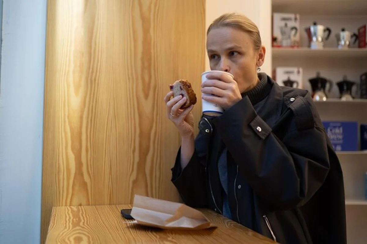 Kobieta delektująca się kawą i ciastem w kawiarni