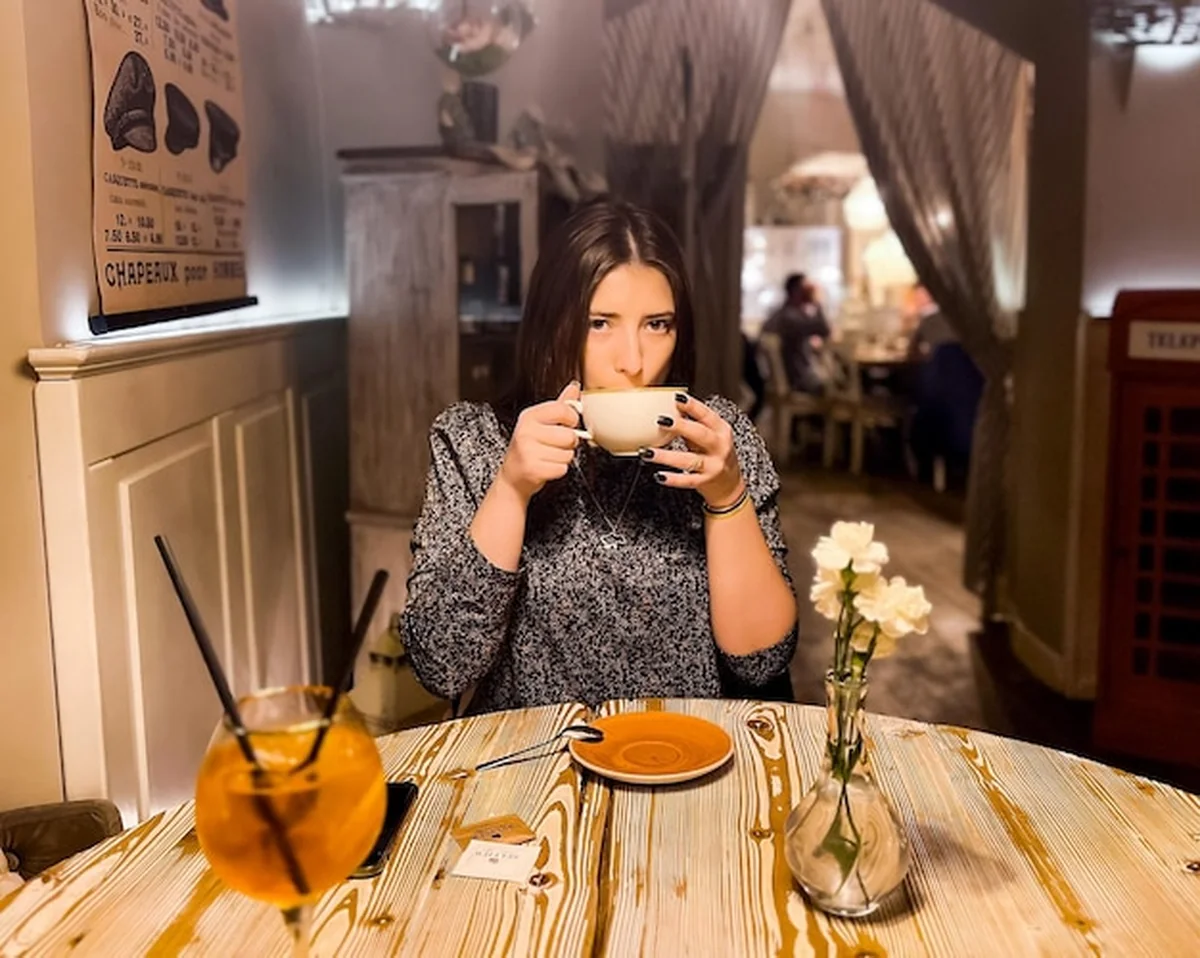 Samotna kobieta w kawiarni pijąca herbatę wieczorem