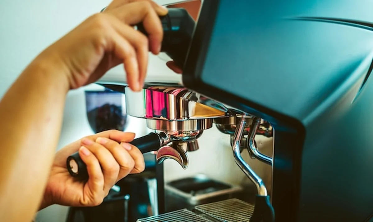 Zbliżenie rąk Baristy przygotowujących ekspres do kawy w kawiarni