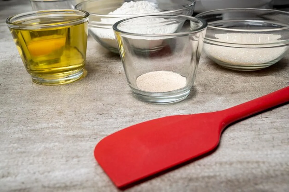 Szklana miska z drożdżem na stole obok innych misek