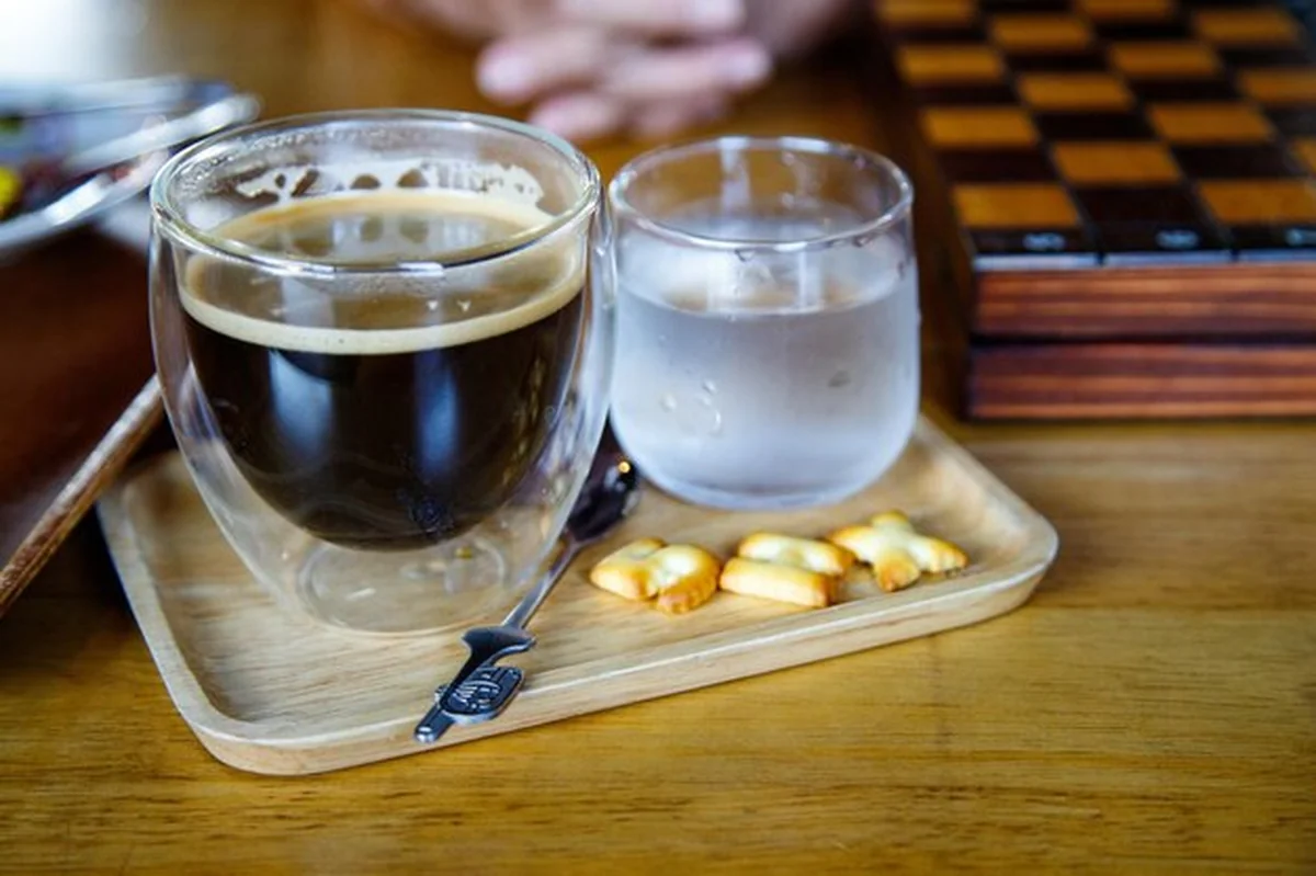 Czarna kawa i woda na stole