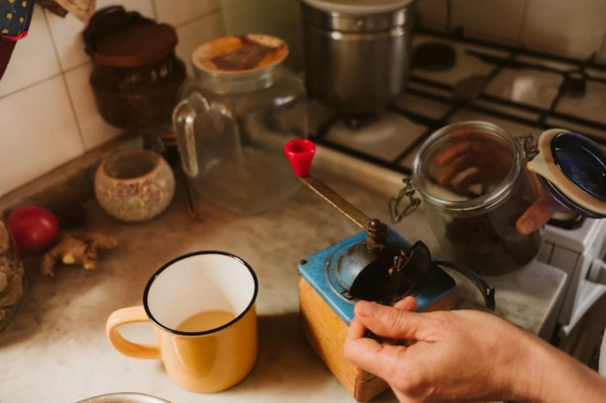 Kobieta mieląca kawę w młynku żarnowym