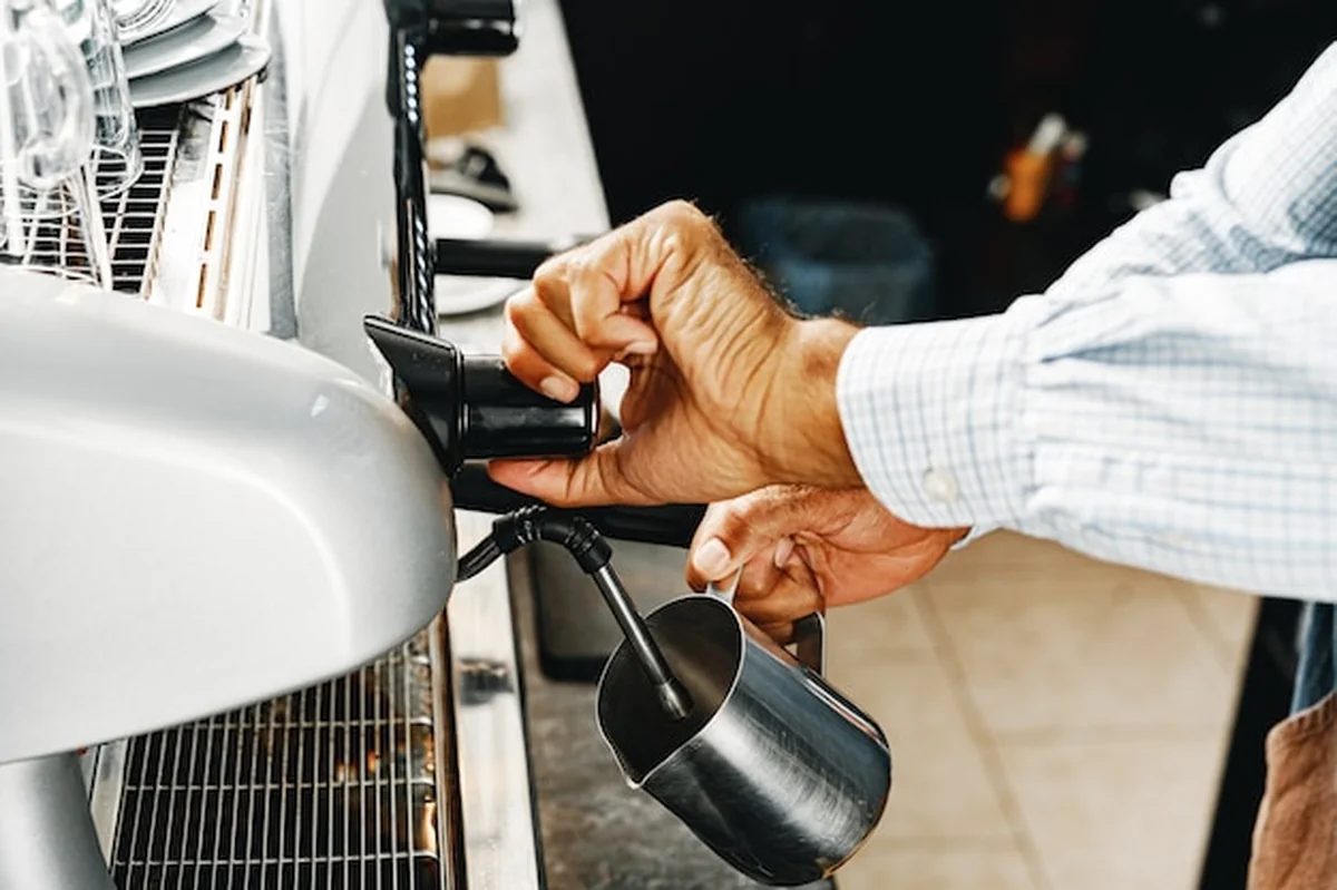 Barista przygotowuje kawę na ekspresie